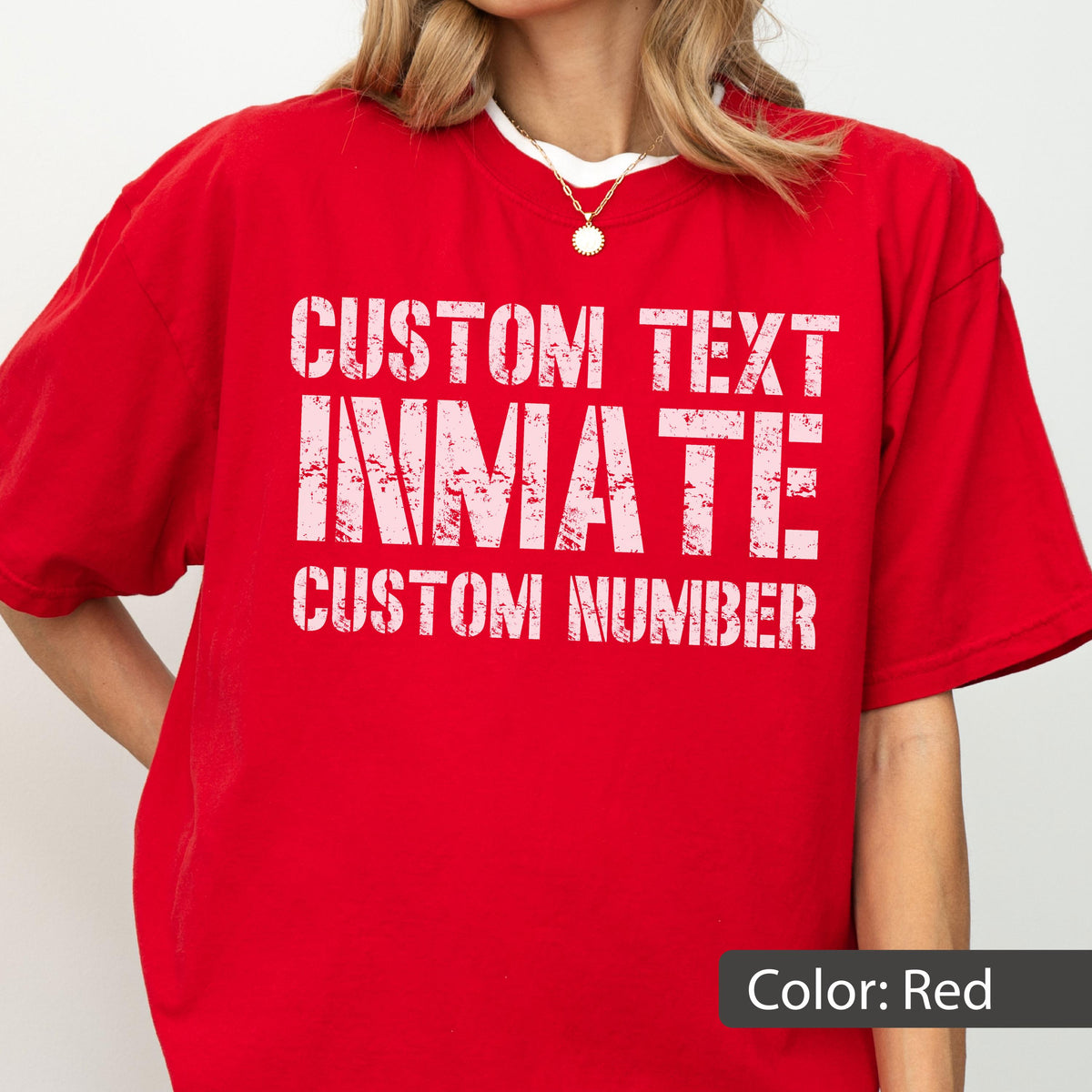 May include: A bright red short-sleeved t-shirt featuring white distressed-style text that reads CUSTOM TEXT, INMATE, and CUSTOM NUMBER. The shirt has a crew neckline and a relaxed fit, showcasing a bold graphic design on the front chest area.