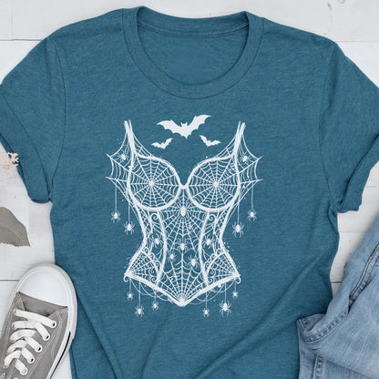 May include: A teal short-sleeved t-shirt featuring a white graphic print of a corset made from spiderwebs, adorned with small hanging spiders and three bats flying above the bodice design, centered on the front of the garment.