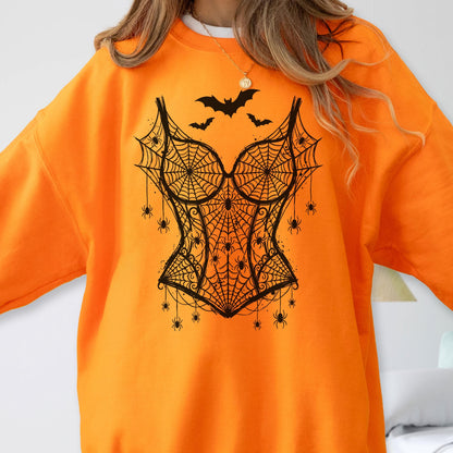 May include: A bright orange long-sleeve sweatshirt featuring a black graphic print of a corset design made of spiderwebs. The design includes multiple small spiders hanging from the web pattern and three bats flying above the corset shape.