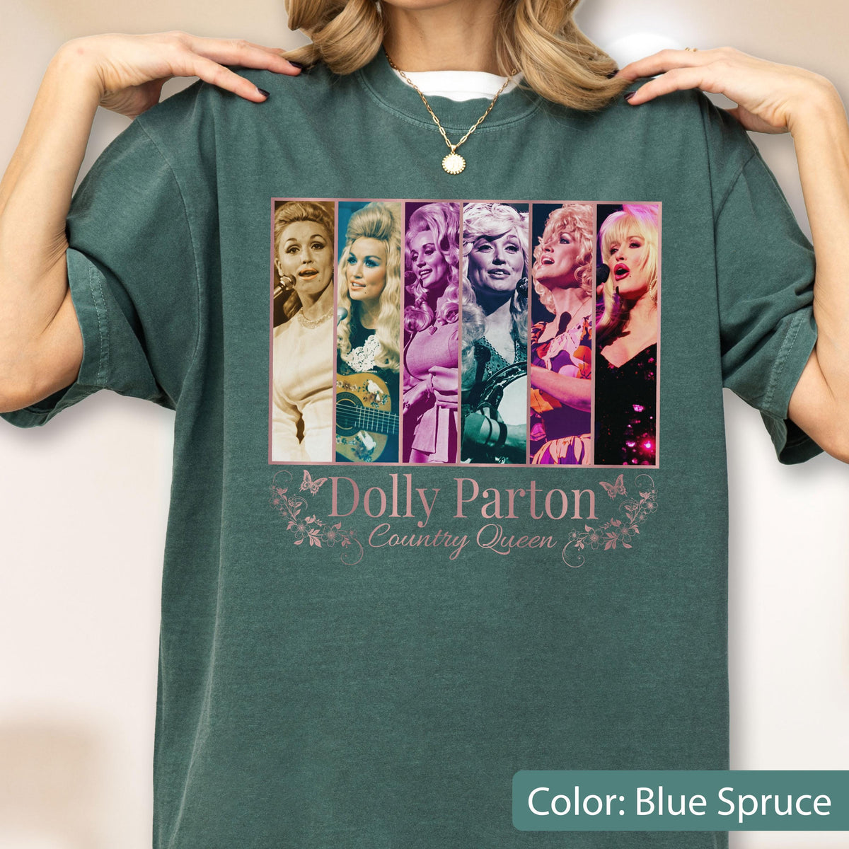 May include: A blue spruce t-shirt featuring a graphic print of six vertical panels showing various portraits of Dolly Parton. Below the images, the text reads Dolly Parton Country Queen in a light pink font, surrounded by small butterfly illustrations.