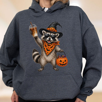 May include: A dark heather gray hooded sweatshirt featuring a graphic of a raccoon wearing a black witch hat with a small pumpkin, heart-shaped sunglasses, and an orange bandana with black bats. The raccoon holds an iced coffee and a pumpkin bucket.