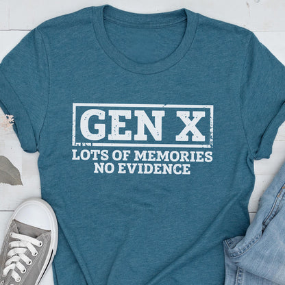 May include: A teal short-sleeved crew neck t-shirt featuring a white rectangular graphic with the distressed text "GEN X" at the top and "LOTS OF MEMORIES NO EVIDENCE" printed in white capital letters underneath the box.