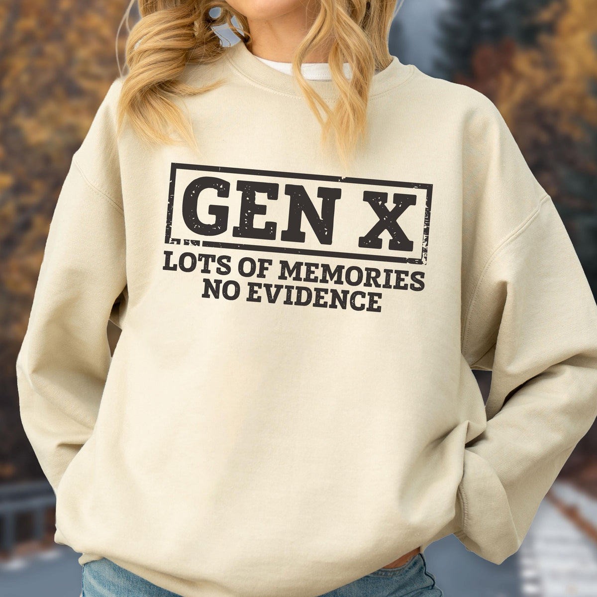 May include: A beige crewneck sweatshirt featuring a black rectangular graphic with the text GEN X in a distressed font, followed by the text LOTS OF MEMORIES NO EVIDENCE in a bold, sans-serif typeface centered on the chest area.