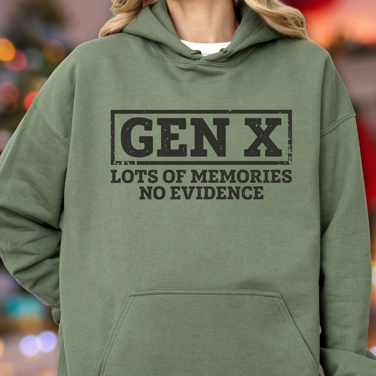 May include: An olive green hooded sweatshirt featuring a black graphic print. The design includes a rectangular border around the text GEN X, followed by the words LOTS OF MEMORIES NO EVIDENCE in a bold, distressed, sans-serif font style.
