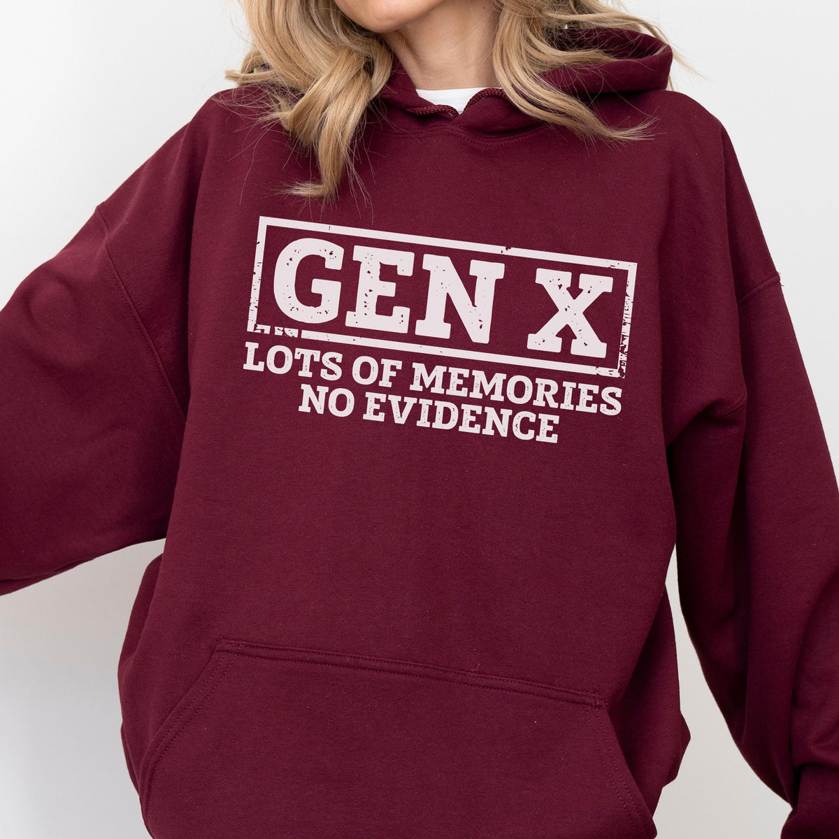 May include: A maroon long-sleeve hooded sweatshirt featuring a white graphic print on the chest. The design includes a rectangular border enclosing the text GEN X, followed by the phrase LOTS OF MEMORIES NO EVIDENCE in a distressed font style.