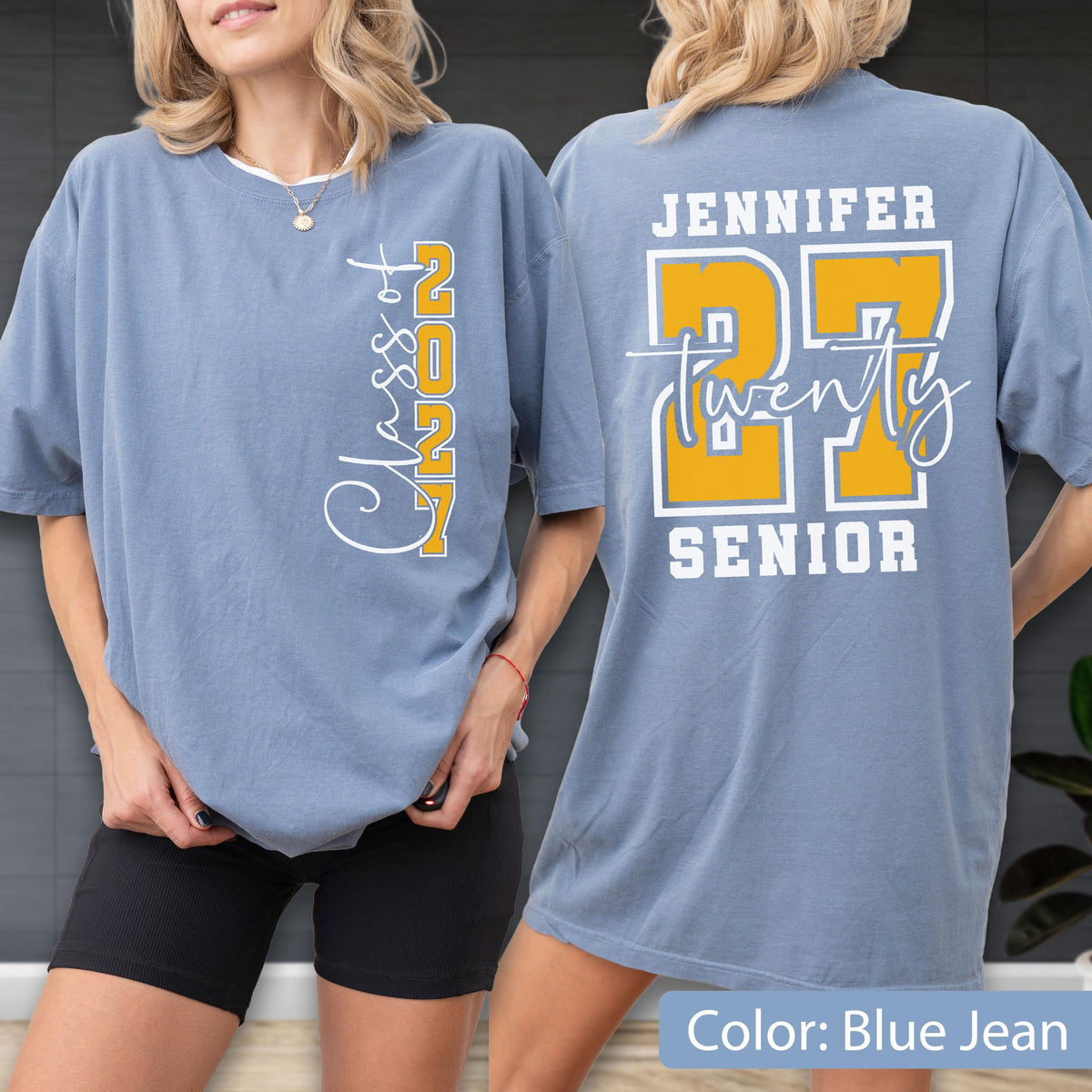 May include: A blue jean colored t-shirt featuring a vertical white and yellow graphic on the front that reads Class of 2027. The back displays the name Jennifer in white, the large yellow number 27, the word twenty in script, and the word SENIOR.