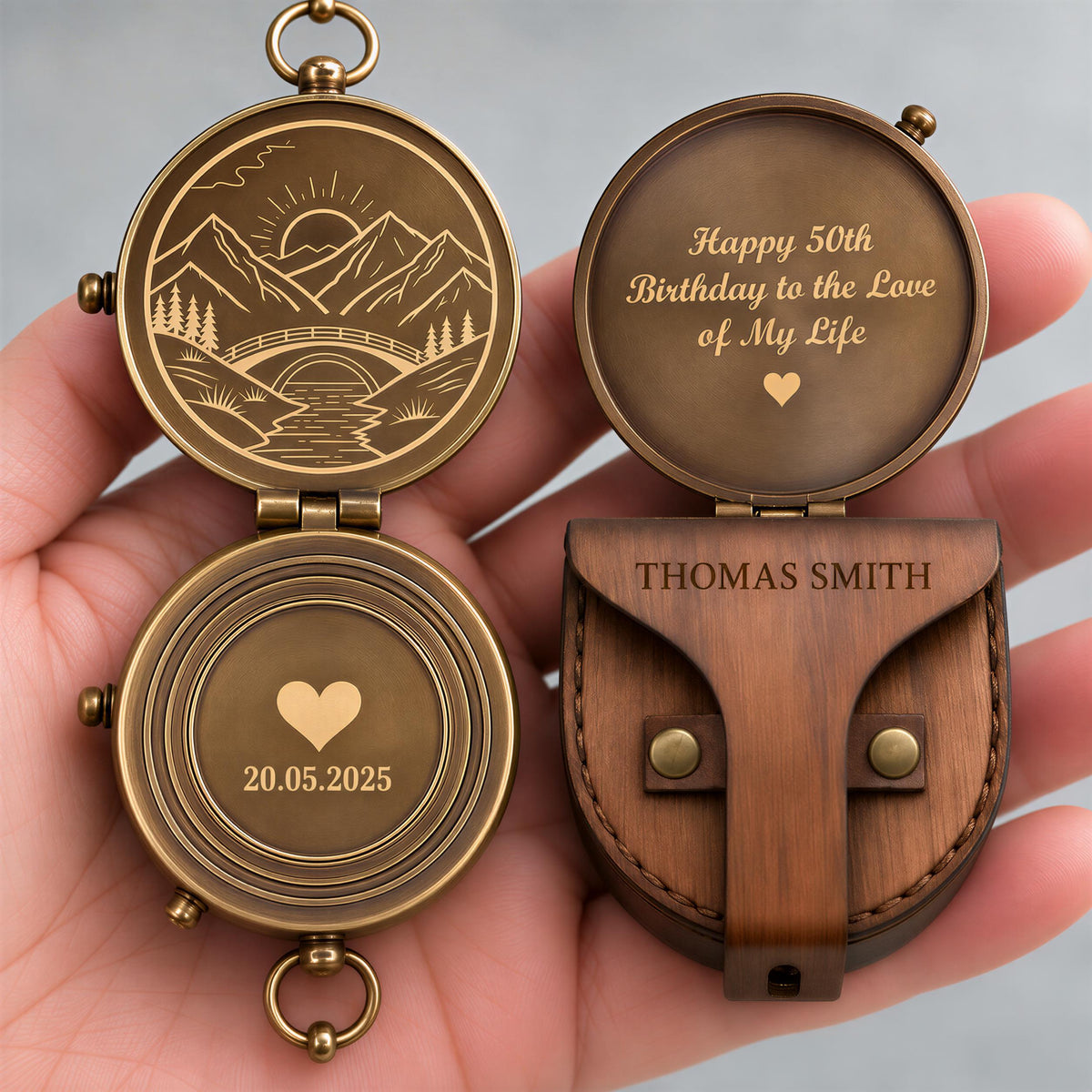 A hand holding a personalized compass with a wooden case and a message engraved on it.