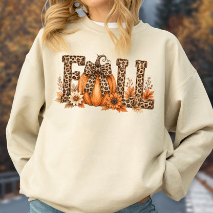 May include: A beige crewneck sweatshirt featuring a graphic print on the chest. The design displays the word FALL in leopard print lettering, with an orange pumpkin wearing a leopard print bow, surrounded by sunflowers and autumn leaves.