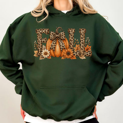 May include: A dark green hooded sweatshirt featuring a graphic print of the word FALL. The letters have a leopard print pattern. An orange pumpkin with a leopard print bow sits in the center, surrounded by sunflowers and autumn leaves.