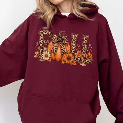 May include: A maroon hooded sweatshirt featuring a graphic print on the chest. The design displays the word FALL in block letters with a leopard print pattern. An orange pumpkin with a leopard print bow sits between the letters, surrounded by sunflowers and autumn leaves.