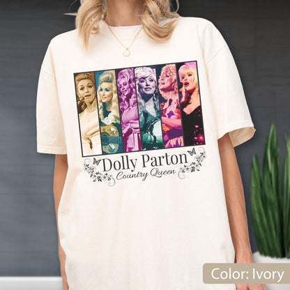 May include: An ivory short-sleeve t-shirt featuring a graphic print of six vertical panels showing various portraits of Dolly Parton. Below the images, the text reads Dolly Parton Country Queen, surrounded by decorative floral and butterfly motifs.
