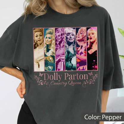May include: A charcoal gray t-shirt featuring a graphic print of six vertical panels displaying various photographs of Dolly Parton. Below the images, the text reads Dolly Parton Country Queen in a decorative font, accented by small butterfly illustrations.