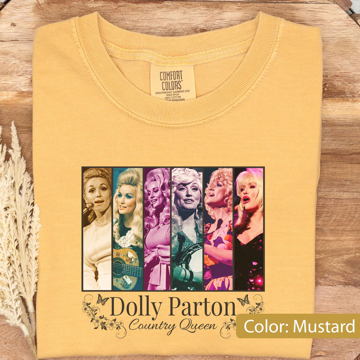 May include: A mustard yellow t-shirt featuring a graphic print of six vertical panels displaying various portraits of Dolly Parton. Below the panels, the text reads "Dolly Parton Country Queen" in a black font, surrounded by small floral and butterfly illustrations.