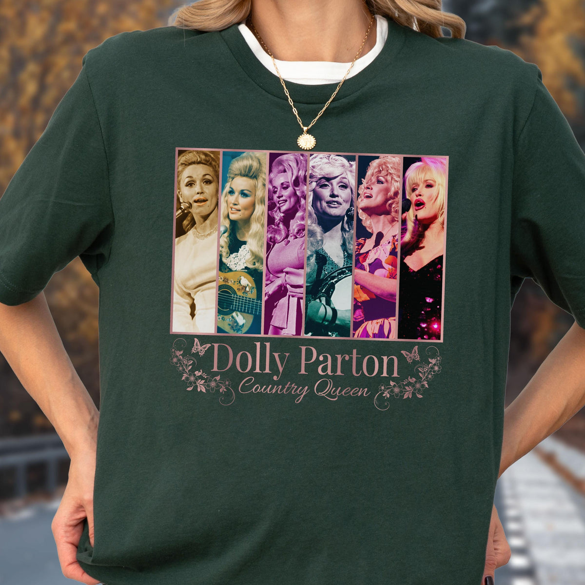 May include: A dark green short-sleeved t-shirt featuring a rectangular graphic with six vertical panels showing different images of Dolly Parton. Below the images, the text reads Dolly Parton Country Queen, decorated with small butterflies and floral vines.