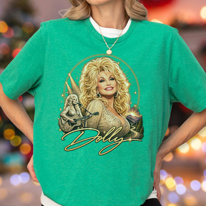 May include: A bright green short-sleeved t-shirt featuring a graphic print of Dolly Parton with voluminous blonde hair. The design includes a smaller image of her playing an acoustic guitar, a mountain landscape, and the name Dolly in gold script.
