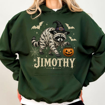 May include: A dark green hooded sweatshirt featuring a graphic of a raccoon wrapped in white bandages, wearing a black witch hat, and holding an orange jack-o'-lantern. The design includes bats, a spider web, and the text JIMOTHY in white.