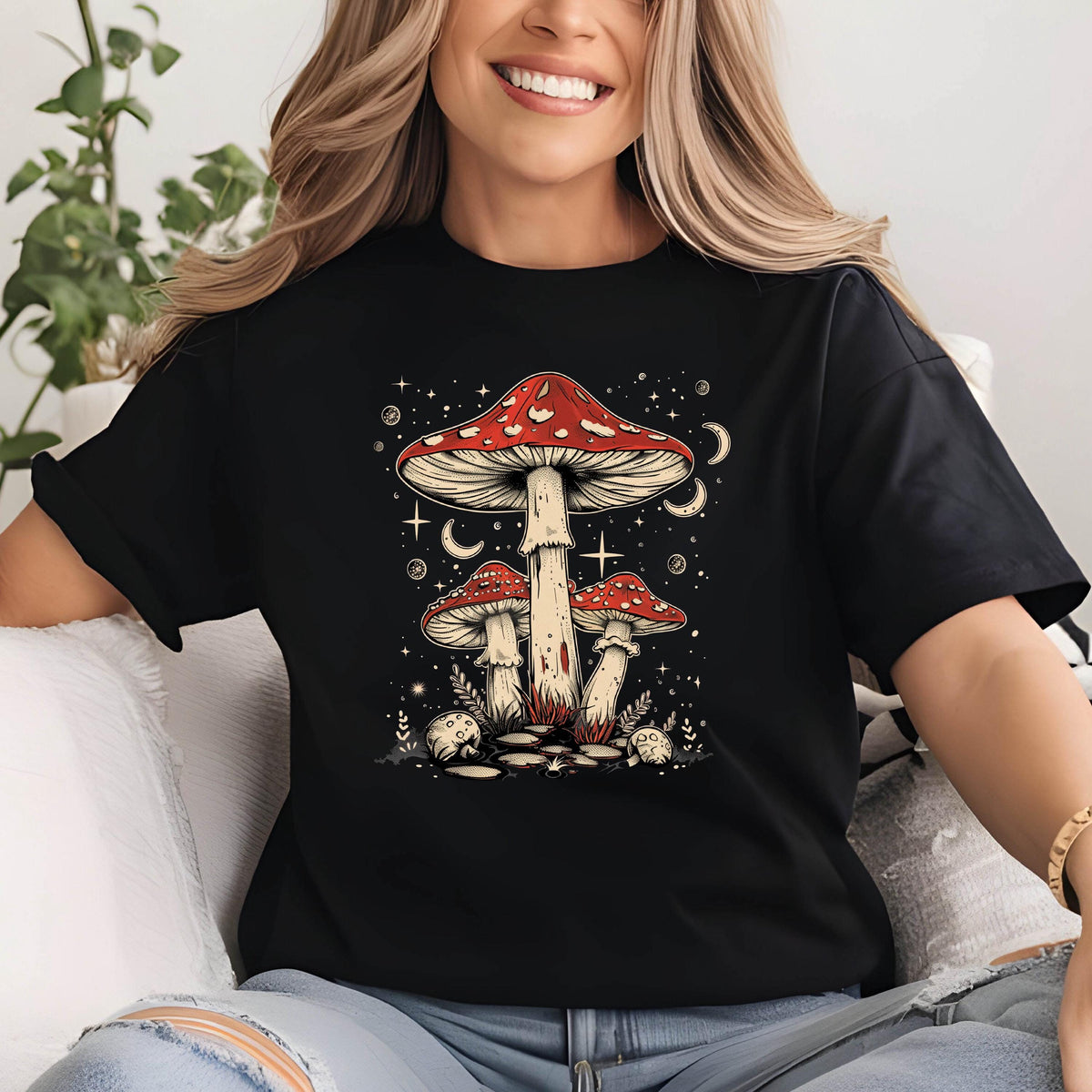 May include: Black t-shirt with a graphic of three red and white mushrooms with white spots. The mushrooms are surrounded by stars and moons.