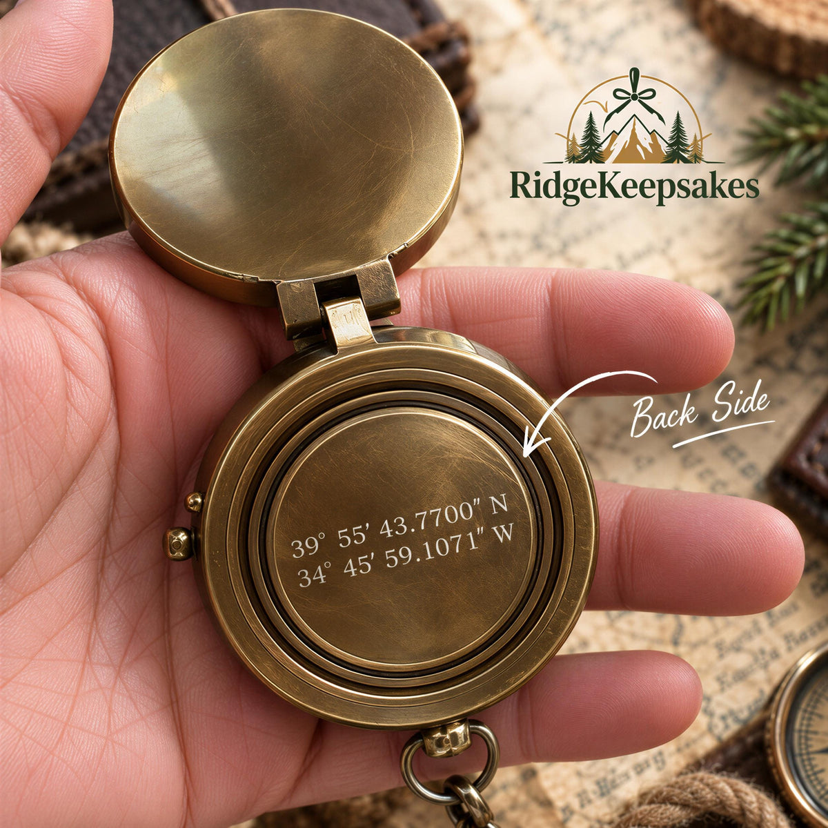 A hand holding a brass compass with a compass rose and coordinates engraved on it.