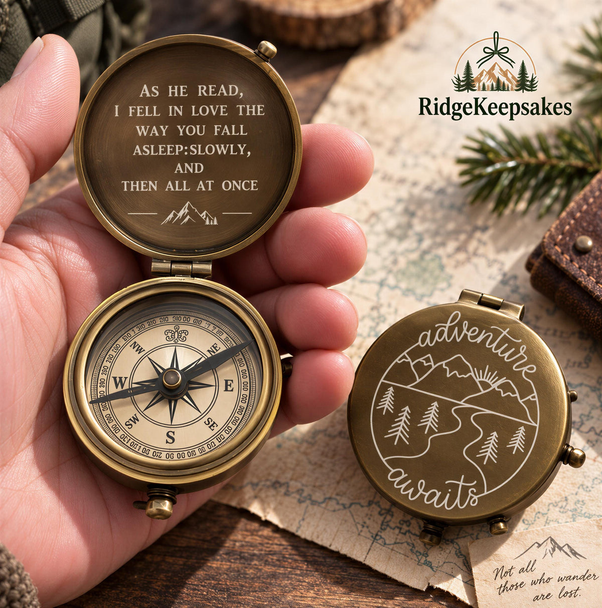 A hand holding an open compass with a quote engraved on it, and a map and pine branches in the background.