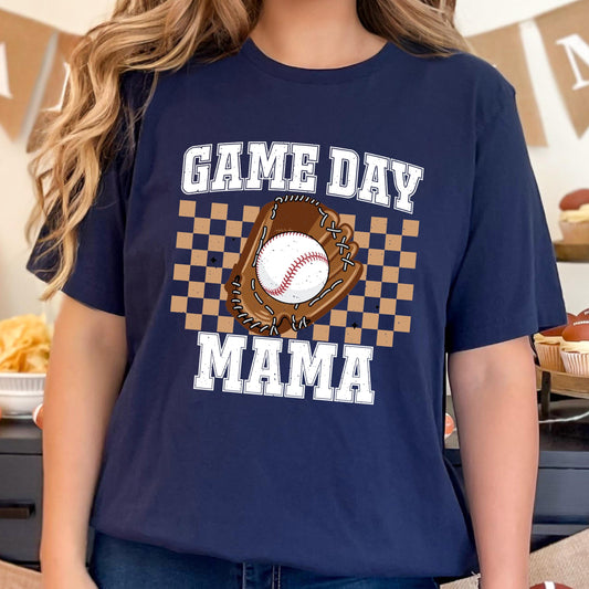 May include: Navy blue t-shirt with the words "GAME DAY MAMA" in white block letters. A baseball glove and baseball are in the center of the shirt, set against a brown and tan checkered background.
