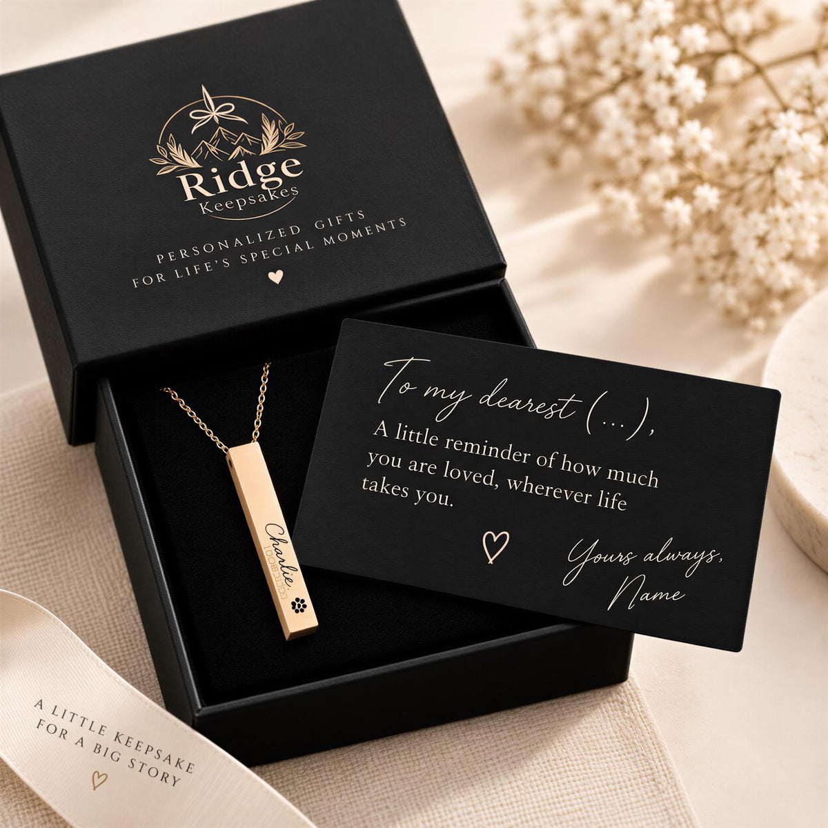 A personalized gift box containing a necklace with a nameplate and a card with a heartfelt message.