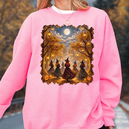 May include: A bright pink long-sleeve sweatshirt featuring a rectangular graphic print of five figures in pointed hats and dresses dancing in a forest at night. The scene includes glowing hanging lanterns, autumn trees, a full moon, and pumpkins.