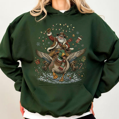 May include: A dark forest green hooded sweatshirt featuring a graphic print of Santa Claus wearing a cowboy hat and riding a flying mallard duck. The design includes colorful Christmas lights, snowflakes, gift boxes, and a stocking.