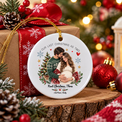 May include: A round white ceramic ornament featuring a printed image of a couple embracing, with the text "OUR LAST CHRISTMAS AS TWO" at the top and "Next Christmas, Three" at the bottom, accented by a Christmas tree, snowflakes, and hearts.