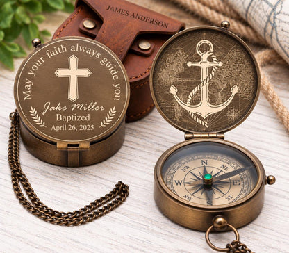 Brass pocket compass with Christian engraving examples, including a cross with personalized text and a large anchor design, displayed with a brown leather pouch.