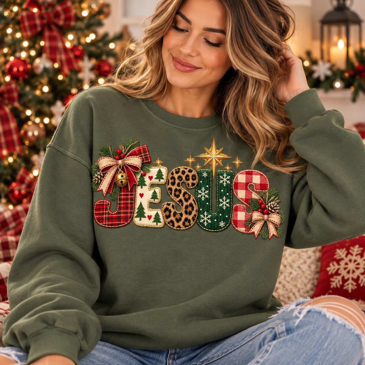 May include: An olive green crewneck sweatshirt featuring the word JESUS in large, textured letters. Each letter has a unique pattern including red plaid, white with green trees, leopard print, green with white snowflakes, and red gingham.