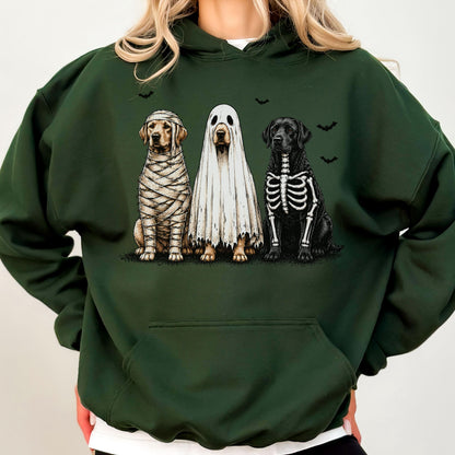 May include: A dark forest green hooded sweatshirt featuring a graphic print of three dogs in Halloween costumes. One dog is wrapped like a mummy, one is wearing a white ghost sheet, and one has a skeleton print. Small black bats fly above them.