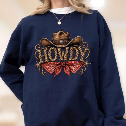 May include: A navy blue crewneck sweatshirt featuring a graphic print of a brown cowboy hat above the word HOWDY written in a rope-style font. Below the text is a red bandana with a white floral pattern and two small metallic stars.