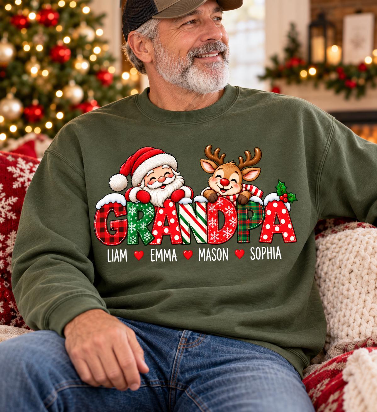 May include: An olive green crewneck sweatshirt featuring a graphic of Santa Claus and a reindeer peeking over the word GRANDPA in festive patterns. Below the text, the names Liam, Emma, Mason, and Sophia are printed, separated by red hearts.