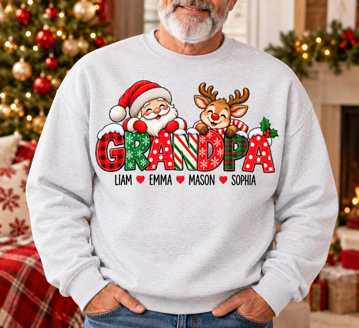 May include: A light gray crewneck sweatshirt featuring a graphic of Santa Claus and a reindeer peeking over the word GRANDPA in festive red, green, and white patterns. Below the text are the names Liam, Emma, Mason, and Sophia with red hearts.